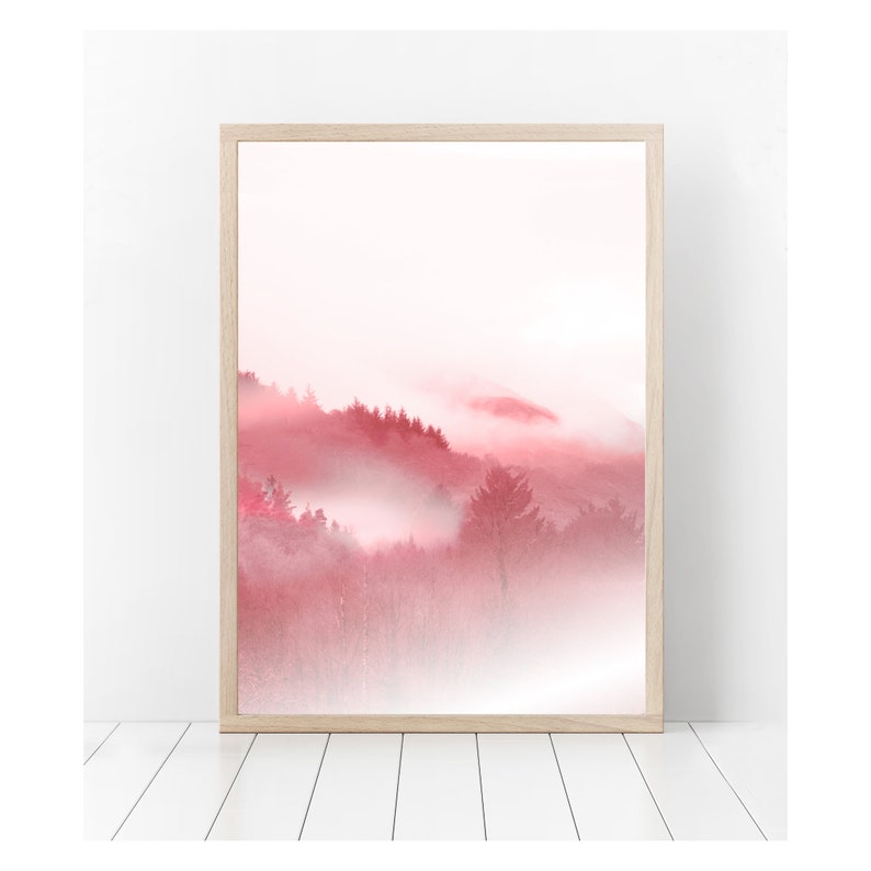 May include: A framed print of a pink and white landscape with a misty forest in the background.