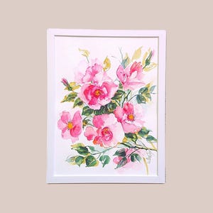 May include: Watercolor painting of pink roses in a white frame. The artwork features a bouquet of roses with green leaves and yellow accents. The flowers are in full bloom, showcasing their delicate petals and vibrant colors. The painting is a floral art piece.
