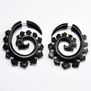May include: A pair of black wooden earrings with a spiral design. The earrings are made of wood and have a natural finish.