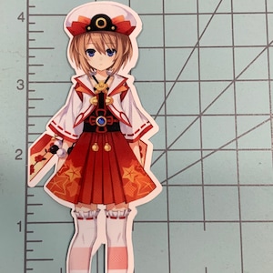 May include: A sticker featuring an anime character with short brown hair, wearing a white and red outfit with a blue sash and a white hat with a red trim. The character has blue eyes and a light pink blush on her cheeks.