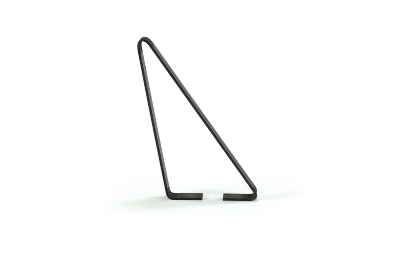 May include: A minimalist, dark metal display stand. The stand has a triangular shape with a curved top and two flat feet. The design is simple and modern, suitable for displaying various items.