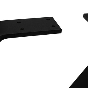 May include: Close-up of black metal table legs. The legs have a modern, angled design with a rectangular mounting plate. The legs are made of solid metal and have a matte finish. The mounting plates have pre-drilled holes for easy installation.