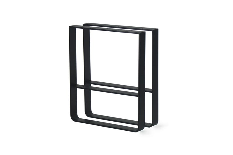 Op de afbeelding: Zwarte metalen handdoekenrek met een minimalistisch design. Het rek heeft twee rechthoekige frames die zijn verbonden door een horizontale balk, waardoor een modern en functioneel stuk ontstaat voor badkamer of keuken.