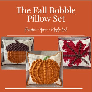 May include: The Fall Bobble Pillow Set features three crocheted pillows. One pillow has an acorn design, another a pumpkin, and the third a maple leaf. The pillows are cream-colored with brown, orange, and red accents.