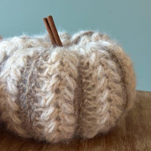 Close-up of ribbed crochet pumpkin showing puff stitch texture and color-changing yarn technique for handmade autumn decoration