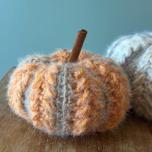 Close-up of ribbed crochet pumpkin showing puff stitch texture and color-changing yarn technique for handmade autumn decoration