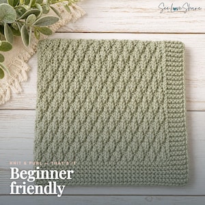 Könnte beinhalten: Eine quadratische, salbeigrüne Häkeldecke mit einem strukturierten diagonalen Stichmuster und einem einfarbigen Rand. Der Text "KNIT & PURL - THAT'S IT" und "Beginner friendly" ist in Weiß in der unteren linken Ecke des Bildes aufgedruckt.