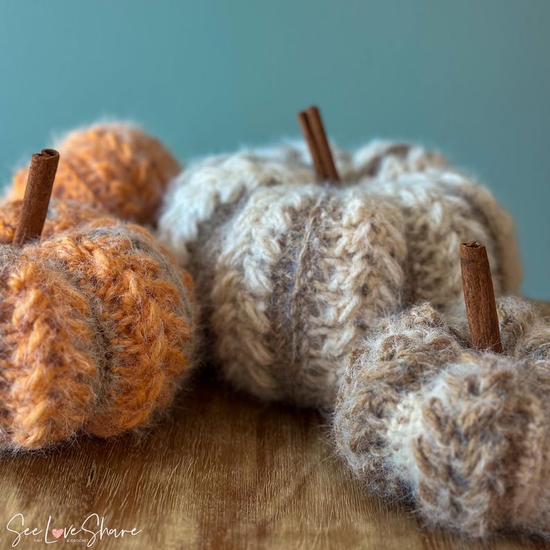 Three ribbed crochet pumpkins in orange, beige, and tan with cinnamon stick stems, made using bulky yarn and puff stitch for cozy fall home decor