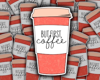 May include: A red and white coffee cup sticker with the text "But first, coffee" in black cursive writing. The sticker has a floral pattern on the bottom half of the cup.
