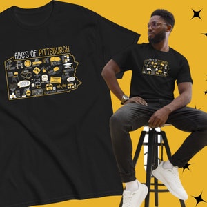 May include: Black t-shirt with a yellow graphic of the state of Pennsylvania with the text "ABC's of Pittsburgh" and various icons representing the city.