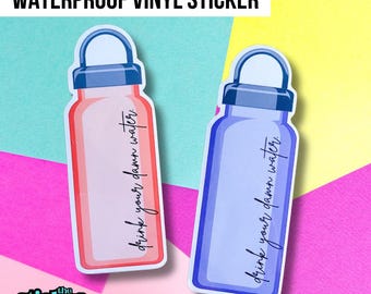 Könnte beinhalten: Zwei wasserdichte Vinylaufkleber in Form von Wasserflaschen. Einer ist rot, der andere blau. Jeder hat den Satz "drink your damn water" in einer handschriftlichen Schriftart. Die Aufkleber befinden sich auf einem farbenfrohen Hintergrund mit dem Text "WATERPROOF VINYL STICKER" oben.