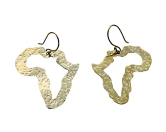 May include: A pair of gold-colored earrings shaped like the continent of Africa. The earrings have a hammered texture and are made of metal.