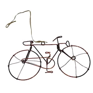 May include: A copper wire bicycle ornament with a brown string for hanging.