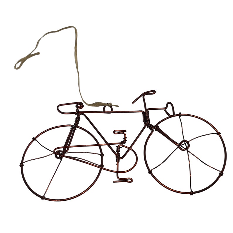 May include: A copper wire bicycle ornament with a brown string for hanging.