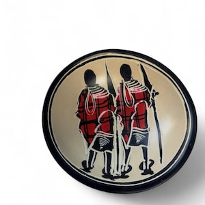 May include: A small, round wooden bowl with a black rim. The bowl is decorated with a hand-painted design of three people in red and black clothing. The people are standing in a line, and they are holding spears.