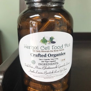 Peut inclure: Un flacon en verre brun rempli de g&eacute;lules, avec une &eacute;tiquette blanche portant l'inscription Herbal Cell Food Plus, 102 Daily Minerals the Body Needs, Crafted Organics, et listant des ingr&eacute;dients comme Irish Sea Moss, Bladderwrack et Burdock Root.