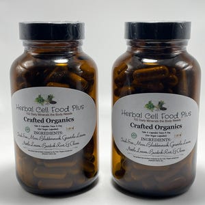 Peut inclure: Deux flacons en verre ambr&eacute; remplis de g&eacute;lules brun fonc&eacute;, chacun avec une &eacute;tiquette blanche indiquant Herbal Cell Food Plus, Crafted Organics, et listant des ingr&eacute;dients comme Irish Sea Moss, Bladderwrack, Graviola Leaves, Nettle Leaves, Burdock Root et Cloves.