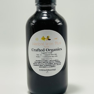 May include: A dark brown glass bottle with a black cap, labeled "Herbal Iron Plus Syrup" and "Crafted Organics". The label lists ingredients and suggested dosage in teaspoons and tablespoons.