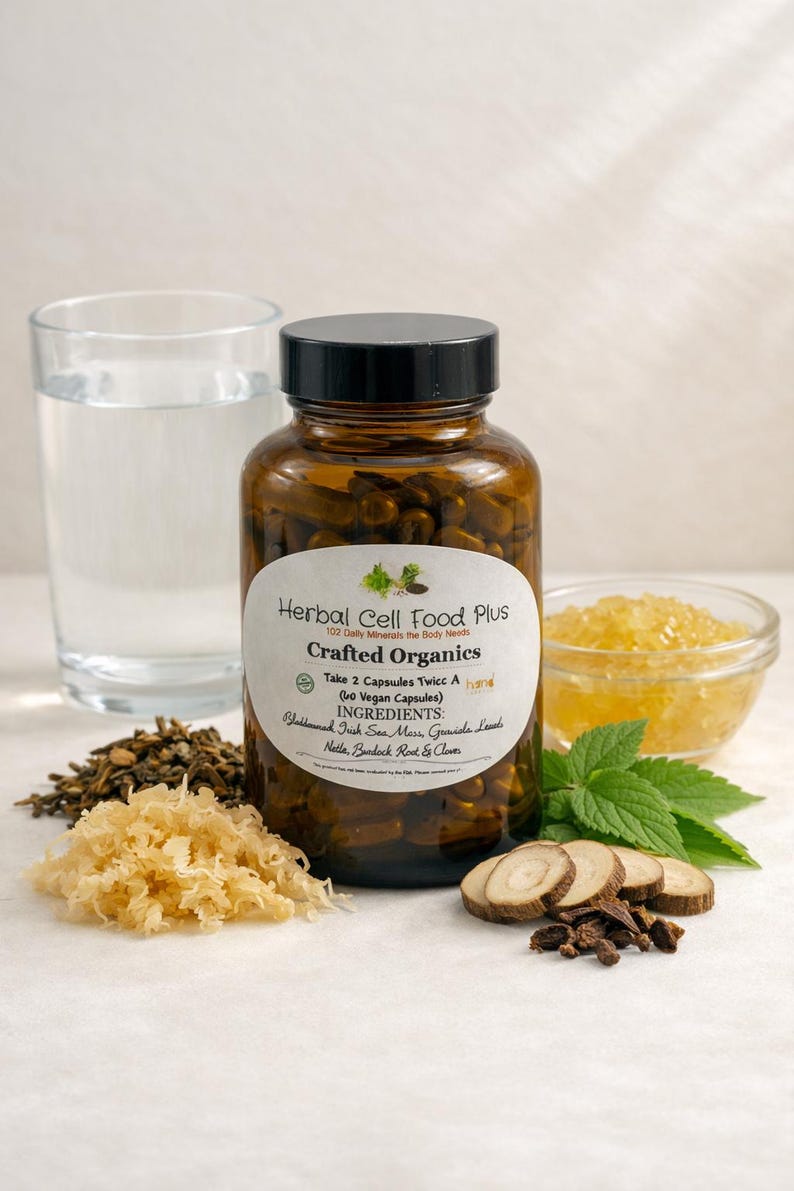 Peut inclure: Un flacon en verre ambr&eacute; avec un couvercle noir contenant des g&eacute;lules sombres, &eacute;tiquet&eacute; Herbal Cell Food Plus Crafted Organics. L'&eacute;tiquette liste des ingr&eacute;dients comme la mousse d'Irlande, la feuille de corossol, l'ortie, la bardane et le clou de girofle. On voit aussi des herbes, de la mousse s&eacute;ch&eacute;e, des racines et un verre d'eau.