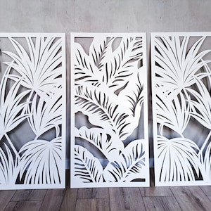 Peut inclure: Trois panneaux rectangulaires blancs avec un motif découpé de feuilles tropicales. Les panneaux sont disposés côte à côte.