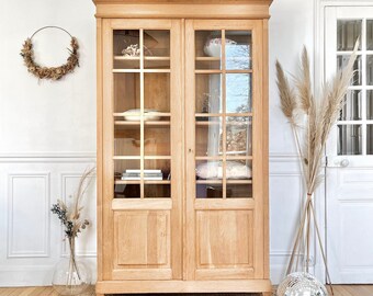 Magnifique armoire vitrée en chêne massif des années 30. Ancienne bibliothèque d’école démontable avec piètement laitonné.