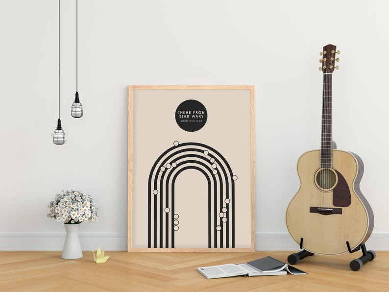 May include: A framed poster with the text "THEME FROM STAR WARS" and a black and white graphic design. An acoustic guitar stands to the right. A white vase with white flowers and a book are on the wooden floor.