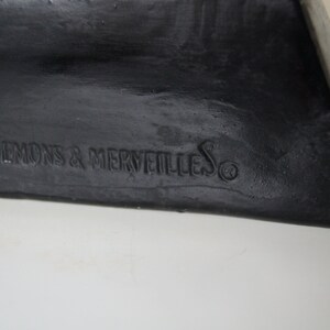 May include: Black and yellow Halloween decoration with the text "By Demons & Merveilles" on the bottom.