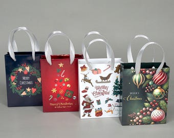 May include: Four rectangular gift bags with white ribbon handles, each featuring unique holiday designs. One is dark blue with a wreath, one red with a tree, one white with various icons, and one dark green with hanging ornaments and Merry Christmas text.