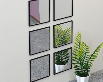 May include: A set of six square mirrors with thin black frames arranged in two vertical columns of three. The mirrors reflect a nearby green potted plant in a white container, along with portions of a room, creating a repeating visual pattern.