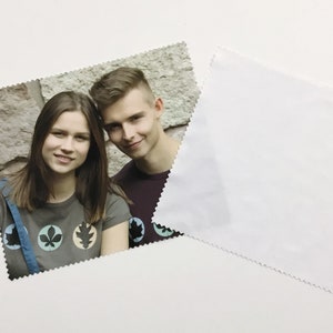 Pode incluir: Uma foto de duas pessoas, um homem e uma mulher, sorrindo para a c&acirc;mera. A mulher est&aacute; vestindo uma camiseta cinza com um desenho de tr&ecirc;s folhas em c&iacute;rculos. O homem est&aacute; vestindo uma camiseta vinho.
