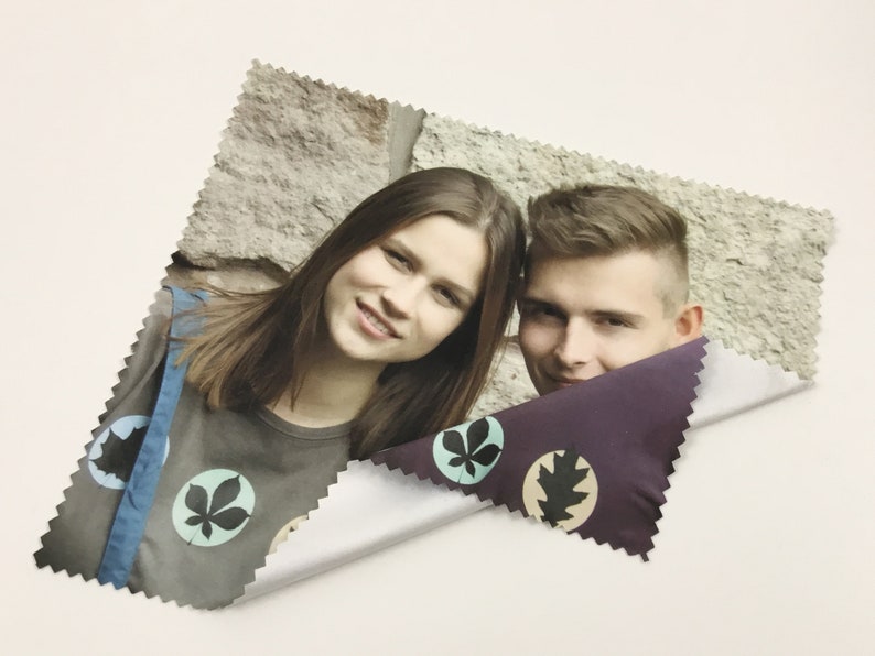 Pode incluir: Um pano de limpeza de microfibra com um design de folhas coloridas. O pano apresenta uma foto de duas pessoas sorrindo para a c&acirc;mera.