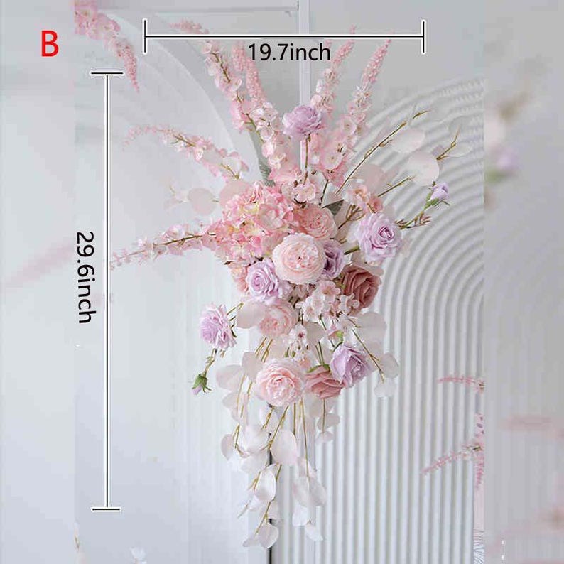 May include: A floral arrangement featuring pink and lavender roses, hydrangeas, and other flowers. The arrangement is approximately 29.6 inches (75.2 cm) tall and 19.7 inches (50 cm) wide. White foliage and accents complete the design.