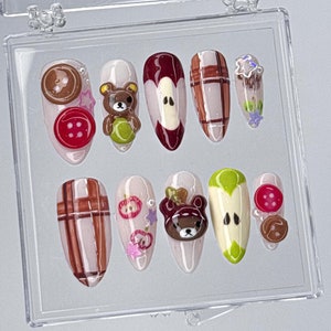 Uñas postizas con motivos caprichosos, uñas postizas con motivos de Rilakkuma y manzana, uñas postizas con un osito y una manzana, uñas con dibujos animados hechas a mano, uñas kawaii