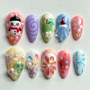 Uñas navideñas kawaii pastel, conejito 3D, muñeco de nieve, caramelos y lazos, diseño navideño dulce, conejito juguetón 3D.
