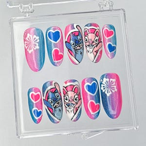 Uñas postizas con dibujos animados extravagantes, diseño de uñas con dibujos animados único, decoradas a mano con personajes adorables, diseño de uñas en azul y rosa con detalles en forma de corazón.