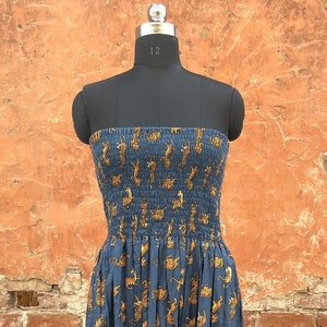 May include: A strapless maxi dress with a blue background and a pattern of yellow tigers. The dress has a fitted bodice and a flowing skirt.