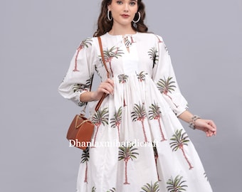 May include: White cotton dress with a palm tree print and a tie at the neck. The dress has a gathered waist and 3/4 sleeves.