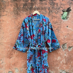 May include: A blue cotton kimono with a floral and bird print. The kimono has a tie belt and long sleeves.