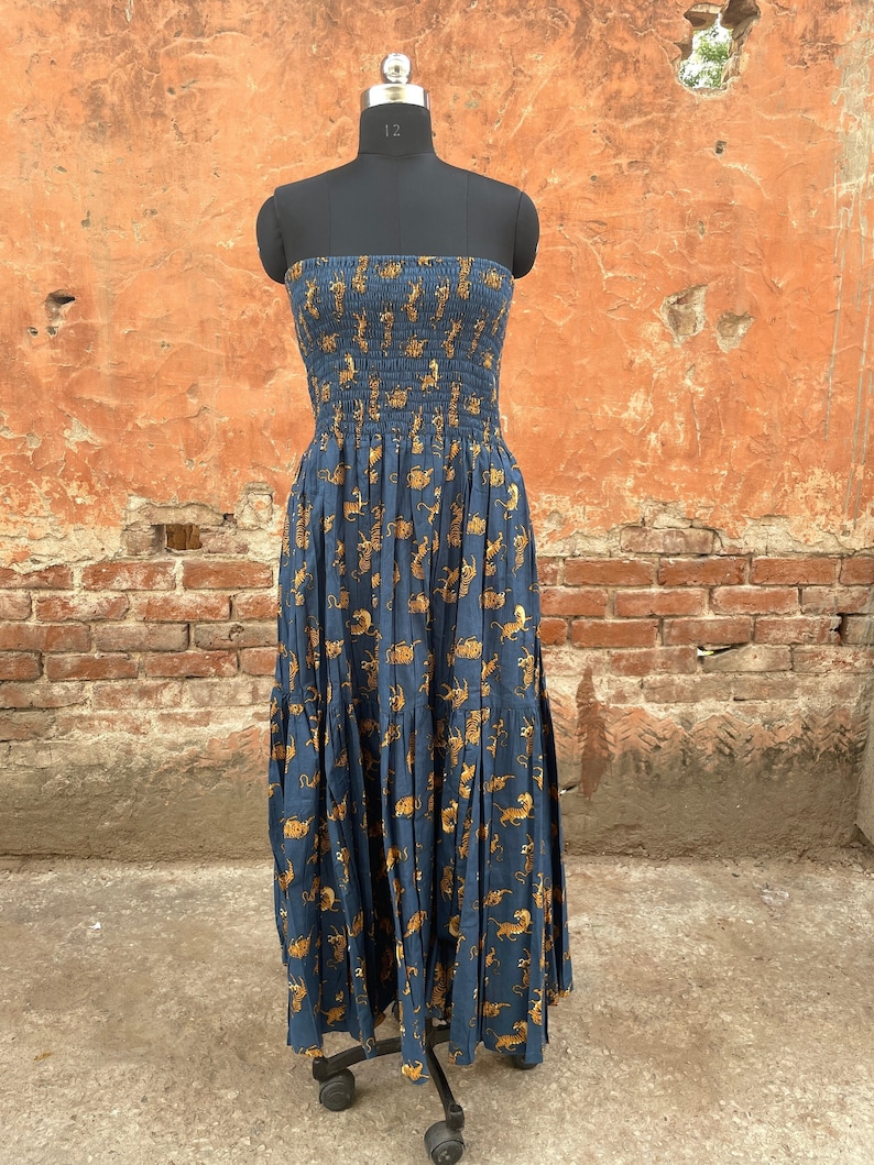 May include: A strapless maxi dress with a blue background and a pattern of yellow tigers. The dress has a fitted bodice and a flowing skirt.