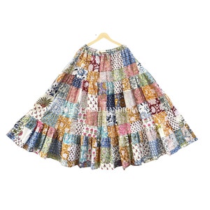 Puede incluir: Una falda larga de patchwork multicolor con un diseño de volantes en capas. La falda está hecha de tela de algodón y presenta una variedad de patrones florales y geométricos.