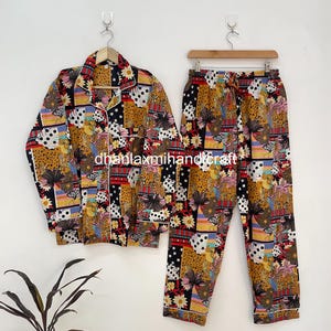 Peut inclure: Un ensemble de pyjama deux pièces avec un motif patchwork vibrant. L'ensemble comprend une chemise boutonnée et un pantalon, tous deux avec un mélange de motifs floraux, à pois et animaliers dans les tons marron, noir, jaune et blanc. L'ensemble est bordé d'un passepoil blanc.