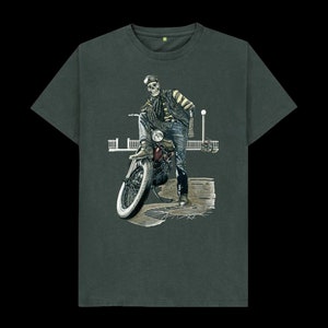 Puede incluir: Camiseta gris oscuro con un diseño de motorista esqueleto. El esqueleto, con una chaqueta de cuero y gafas, se apoya en una moto vintage roja y negra. El diseño es detallado y artístico, con un neumático blanco.