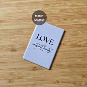Könnte beinhalten: Ein rechteckiger weißer Magnet mit den Worten "LOVE without limits" in schwarzer Schrift. Der Magnet liegt auf einer Holzoberfläche. Ein kreisförmiges Etikett oben zeigt "Motiv-Magnet".