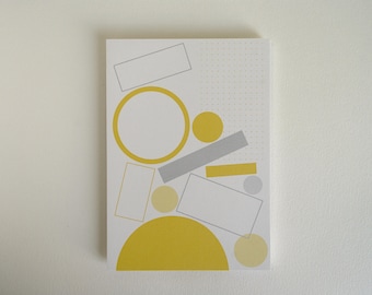 May include: A white card with a yellow and gray geometric pattern. The pattern includes circles, squares, and rectangles. The background is a white dotted pattern.