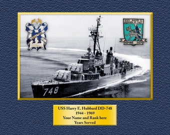 May include: A black and white photograph of a US Navy destroyer, the USS Harry E. Hubbard DD-748, sailing on the water. The ship's number, 748, is visible on the hull. The ship's crest is visible in the upper right corner of the image. The crest features a dog and the text "USS Harry E. Hubbard DD-748" and "Nomine Diem".
