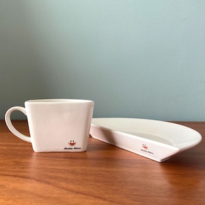 May include: White ceramic mug and matching plate with a watermelon graphic and the text "Healthy Habits".