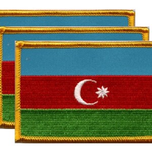 May include: Three embroidered patches featuring the flag of Azerbaijan. Each patch has a light blue top, a red middle section with a white crescent and star, and a green bottom. The patches are rectangular with a gold border.