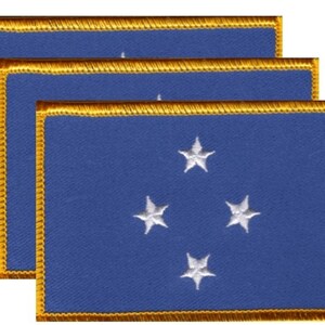 May include: Three blue rectangular patches with four white stars embroidered on each. The patches have a gold border with a gold fringe. The patches are stacked on top of each other.