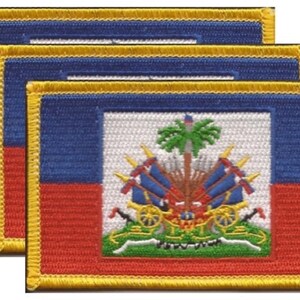 May include: Three embroidered patches featuring the flag of Haiti. Each patch has a rectangular shape with a blue upper section, a red lower section, and a white central panel displaying the Haitian coat of arms. The patches have a yellow border.