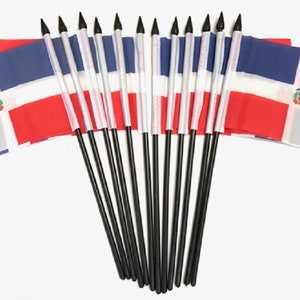 May include: A collection of small Dominican Republic flags. Each flag features a white cross, a coat of arms, and red and blue sections. The flags are attached to black poles with pointed tips.